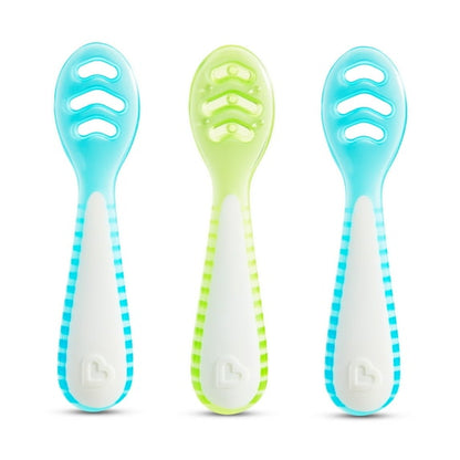 Three baby spoons with blue and green handles on a white background