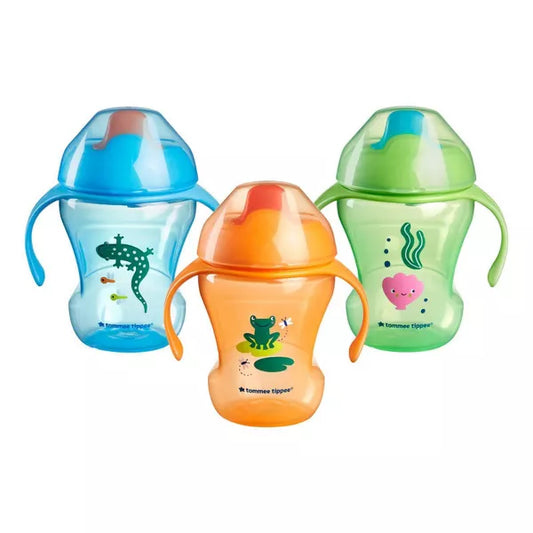 Three colorful sippy cups with frog designs on a white background