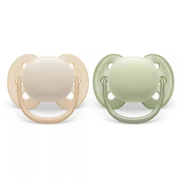Two baby pacifiers, one beige and one green, on a white background