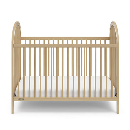 A wooden baby crib with a white mattress, designed for infants and toddlers