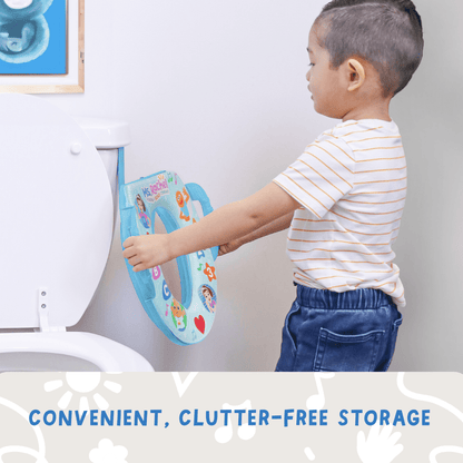 A child places a blue potty training seat with handles on a white toilet
